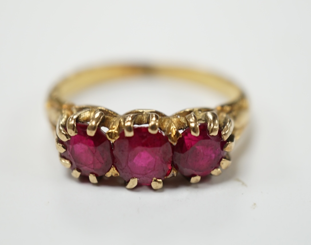 A yellow metal and three stone synthetic ruby set ring, size M, gross weight 4.8 grams. Fair condition.